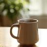 Eine heiße Tasse Tee auf einem Tisch mit weichem Morgenlicht